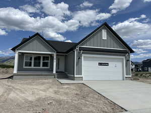 View of front of home featuring an attached garage, concrete driveway, board and batten siding, and covered porch