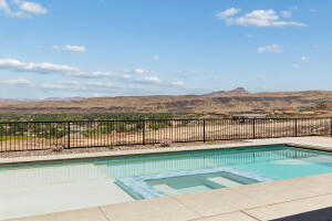 View of swimming pool featuring a pool with connected hot tub, a mountain view, and a patio