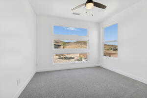 Spare room featuring baseboards, a ceiling fan, and carpet flooring