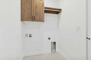 Laundry room with cabinet space, hookup for a washing machine, baseboards, and hookup for an electric dryer