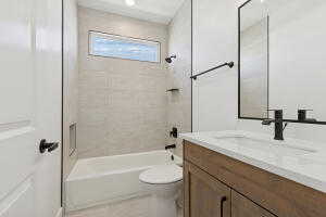Bathroom featuring vanity, toilet, and  shower combination
