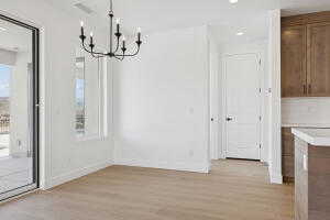 Unfurnished dining area with a chandelier, light wood-type flooring, baseboards, and recessed lighting