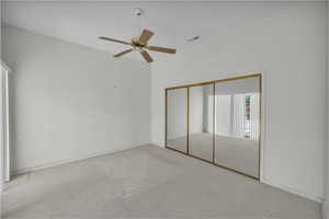 Unfurnished bedroom with carpet, a closet, ceiling fan, and baseboards
