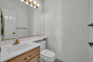 Half bathroom featuring vanity and toilet