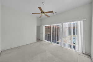 Carpeted spare room featuring healthy amount of natural light, a ceiling fan, and baseboards