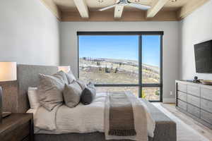 Bedroom featuring light wood-type flooring, recessed lighting, wood ceiling with exposed beams, and a ceiling fan
