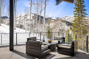 Snow covered patio featuring a mountain view and a balcony
