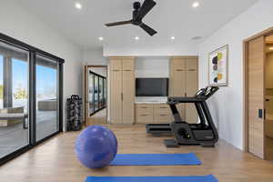Exercise area featuring light wood-type flooring, recessed lighting, ceiling fan, and baseboards