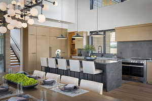 Kitchen featuring modern cabinets, oven, a sink, wood finished floors, and a center island