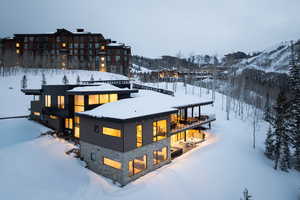 Snow covered house featuring stone siding