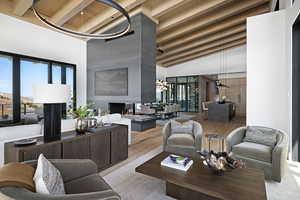Living area with wood finished floors, high vaulted ceiling, and wood ceiling with exposed beams