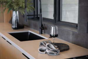 Kitchen view of a sink and light countertops