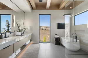 Full bath with tile patterned flooring, double vanity, a freestanding tub, wood ceiling with exposed beams, and tile walls