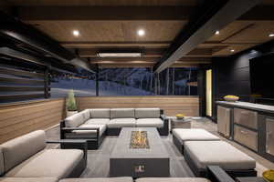 Common area featuring wooden ceiling with exposed beams, wooden walls, and recessed lighting