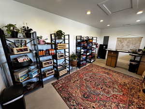 Office space featuring recessed lighting, attic access, concrete flooring, and electric panel