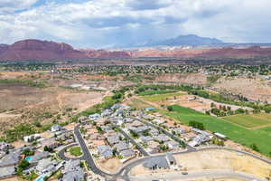 Aerial view of property and surrounding area featuring a mountain backdrop and nearby suburban area