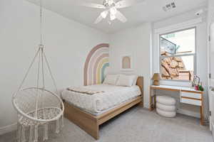 Carpeted bedroom with ceiling fan and baseboards