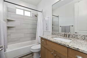 Bathroom with shower / bath combination with curtain, vanity, and light wood-style flooring