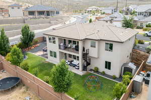 Rear view of house featuring a trampoline, a fenced backyard, a patio area, and a residential view