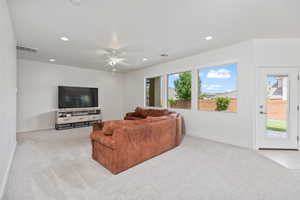 Living room featuring light carpet, recessed lighting, and a ceiling fan