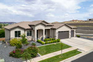 View of front of property with stone siding, a porch, stucco siding, an attached garage, and concrete driveway