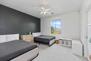 Carpeted bedroom featuring ceiling fan