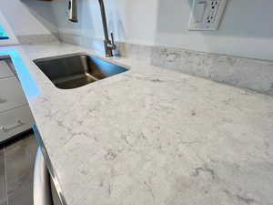Kitchen view of a sink and light stone countertops