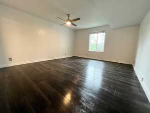 Master bedroom without furniture with dark wood finished floors, ceiling fan, and great views out the window