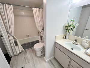 2nd Bathroom with vanity, shower / tub combo with curtain, toilet, and ceramic floors