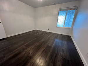 2nd bedroom with dark wood-style floors  and entry into 2nd bathroom