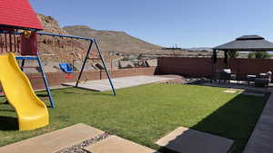 View of yard with a playground, a mountain view, an outdoor hangout area, and a gazebo