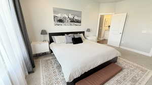 Bedroom with baseboards and light colored carpet