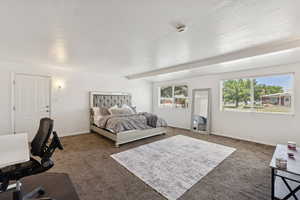 Bedroom with carpet, baseboards, and a desk