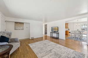 Living area featuring a chandelier, light wood-type flooring, and baseboards