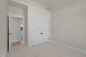 Unfurnished bedroom featuring carpet floors, a closet, and baseboards