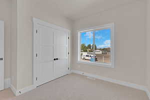 Unfurnished bedroom with carpet floors, baseboards, and a closet