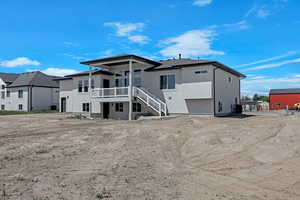 Rear view of property featuring stucco siding, central AC, and stairs