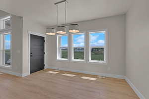 Unfurnished dining area featuring light wood-style floors and baseboards