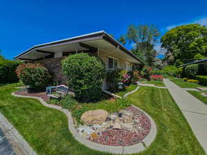 View of home's exterior featuring a yard and brick siding