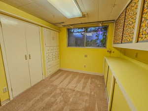 Unfurnished bedroom or craft room with light colored carpet