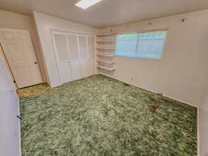 Unfurnished bedroom with carpet, a closet, and baseboards
