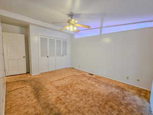 Unfurnished bedroom featuring a closet, carpet flooring, a ceiling fan, and baseboards
