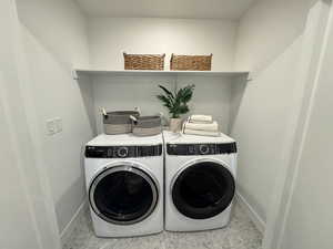 Laundry area with washing machine and dryer and baseboards