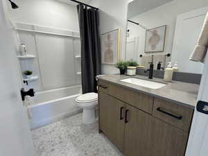 Bathroom featuring vanity, shower / tub combo, and toilet