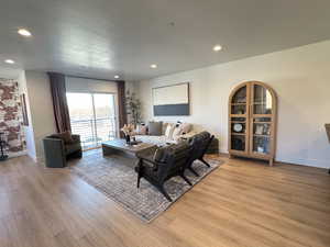 Living room with light wood-style flooring, baseboards, and recessed lighting