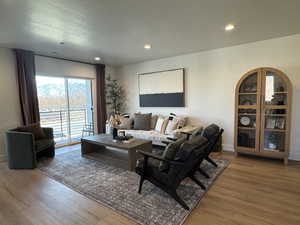 Living area with wood finished floors, recessed lighting, and baseboards