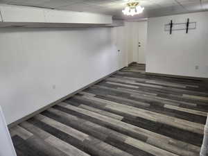 Finished basement featuring dark wood finished floors and baseboards
