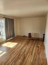 Spare room with hardwood / wood-style floors and baseboards