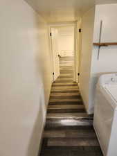 Corridor featuring washer / dryer, wood finished floors, and baseboards
