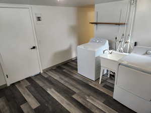Laundry room with separate washer and dryer, dark wood-style flooring, and electric panel